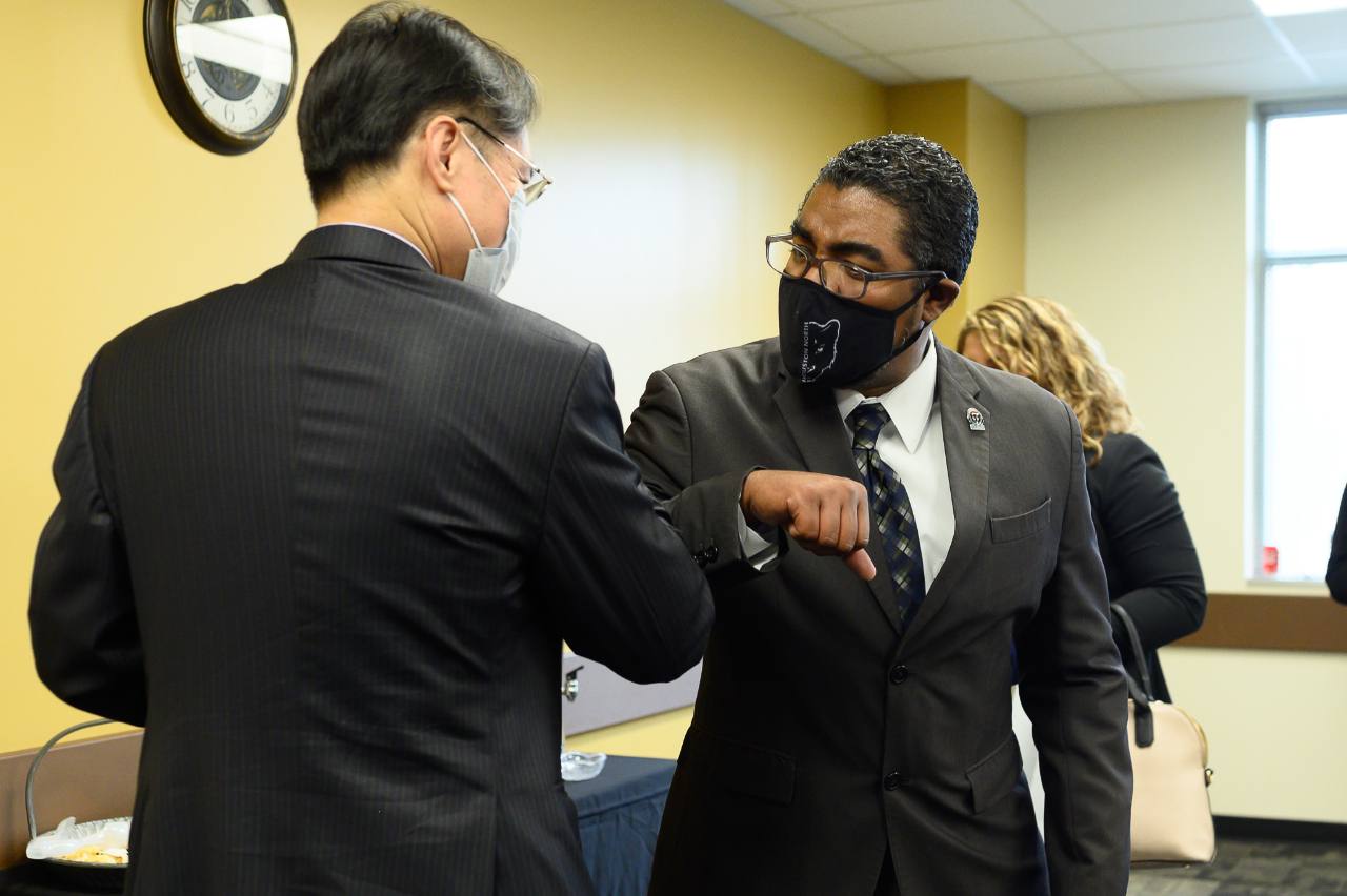 Director General Robert Lo of Taipei Economic and Cultural Office in Houston and Dr. Quentin Wright, president of Lone Star College Houston North greeted each other with elbow bumps at the Laptop Donation Event