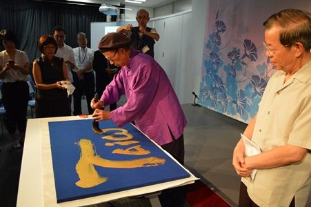 現場揮毫「Taiwan」的徐永進〈中央〉與謝長廷駐日代表〈右〉