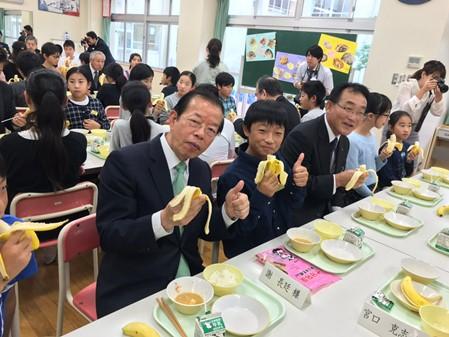 富山県内の小学校給食で台湾バナナのおいしさをPRする謝長廷・駐日代表（左１）