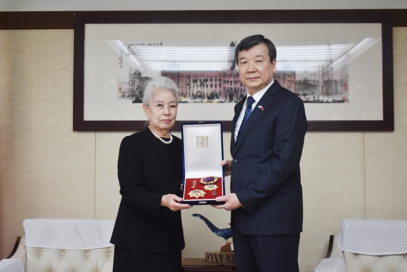 中華民国（台湾）政府は、今年4月13日に逝去された「日華（日台）親善協会全国連合会」の藤井孝男会長に「大綬景星勲章」を授与した。同勲章の伝達式が7月15日、駐日代表処にて藤井会長の関係者ら出席の下、執り行われた。式典では、李逸洋・駐日代表が祝辞（頌詞）を読み上げた後、藤井会長の夫人藤井南七子女史に「大綬景星勲章」が手渡された。写真：李逸洋・駐日代表（右）、藤井南七子夫人（左）