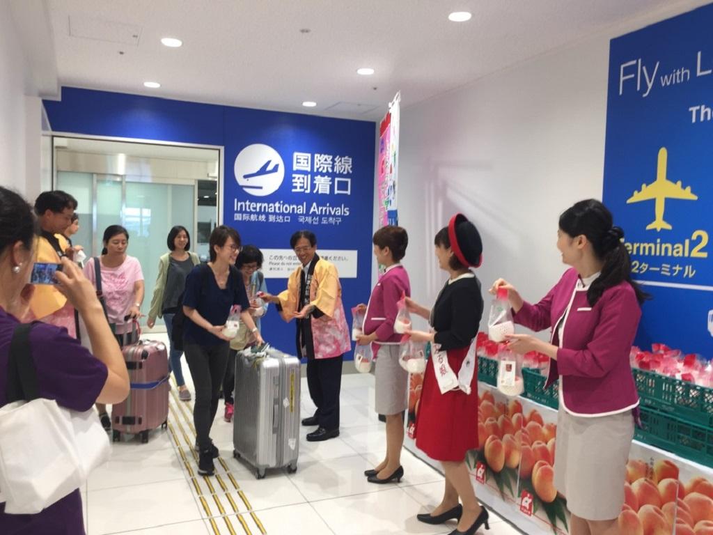 2.陳訓養處長(右四)發送水蜜桃予我觀光客