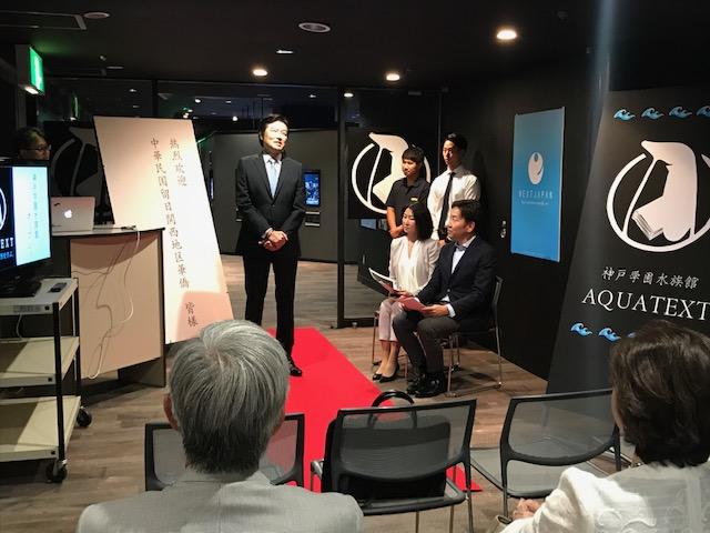 挨拶する李世丙・駐大阪弁事処長 (起立者)。蒋恵萍・神戶学園総長(着席者、右2)