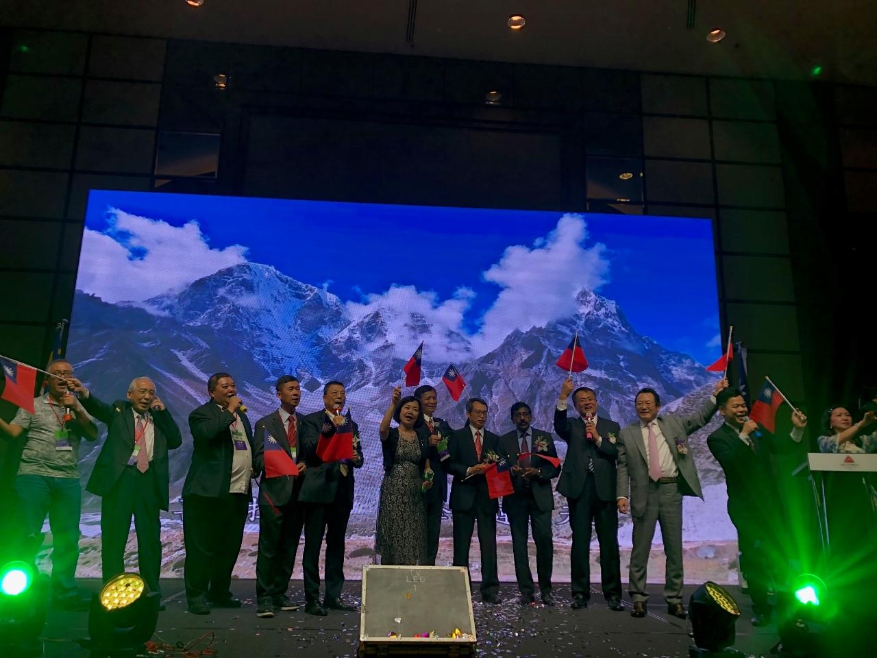 Representative Anne Hung (sixth from left) and the distinguished guests wave the flags of the Republic of China and sing “Ode to the Republic of China" together.
