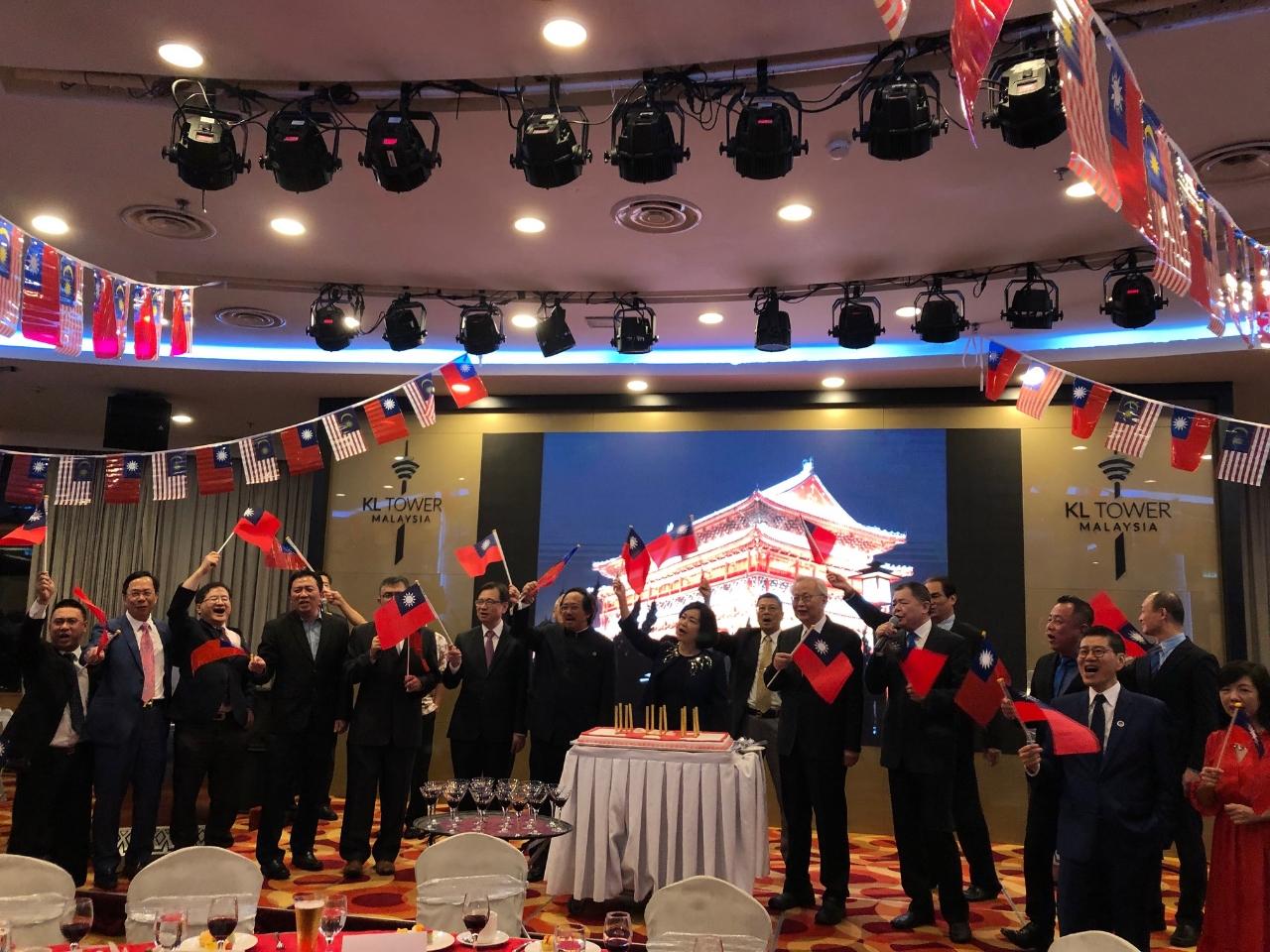 Representative Anne Hung (center) and the distinguished guests wave the flags of the Republic of China and sing “Ode to the Republic of China" together.