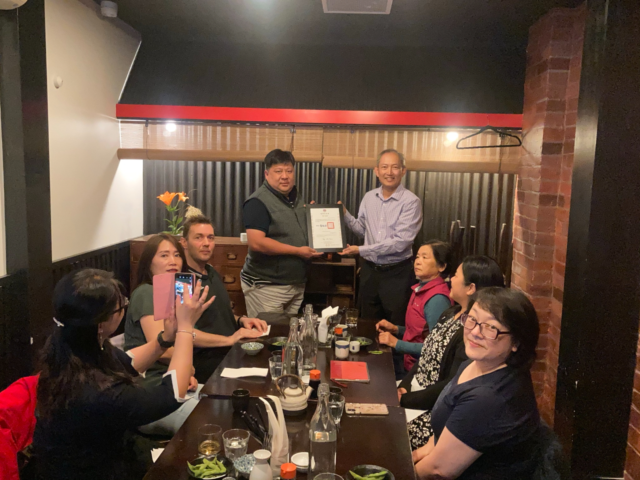 陳代表（右站立者）夫婦晚宴威靈頓華光協會楊俊傑會長（左站立者）夫婦等，並轉致僑務委員會感謝狀感謝楊會長率華光協會辦理109年國慶慶祝活動。