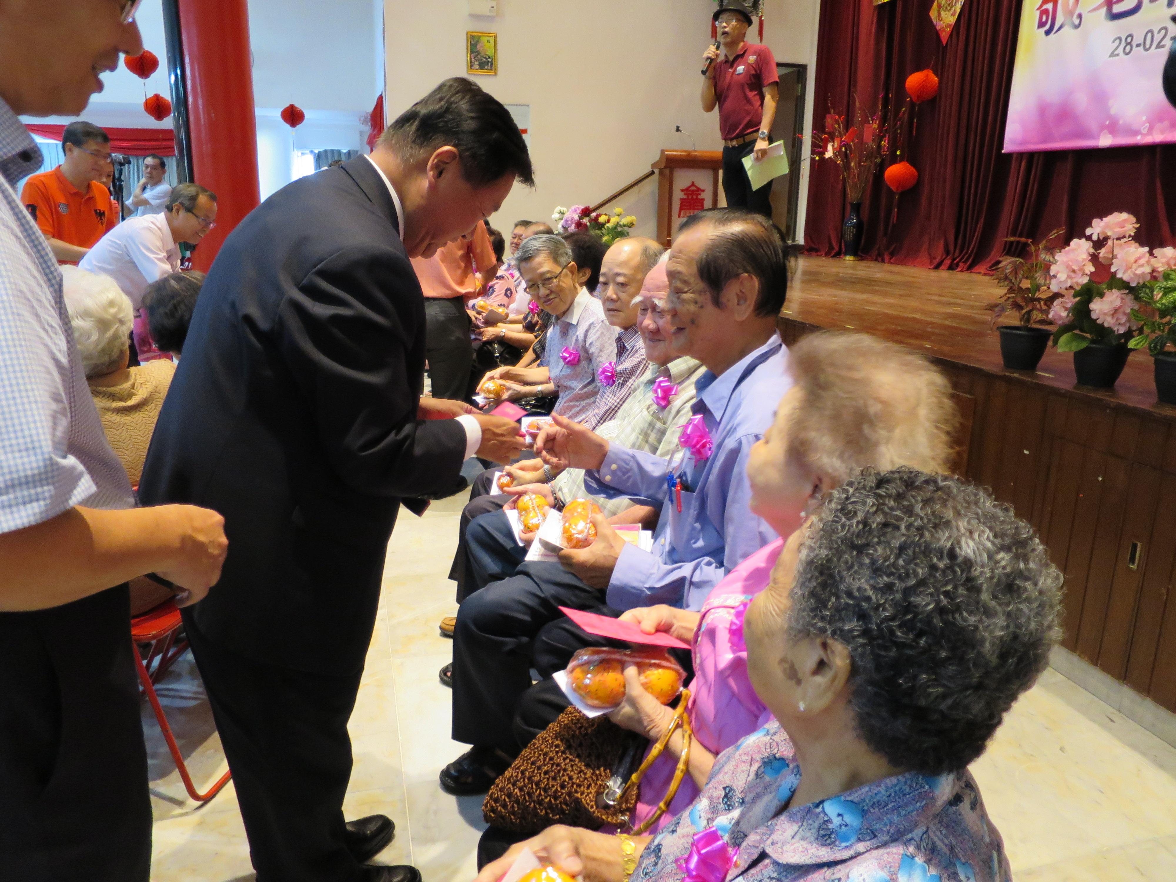 張大使（圖中，站立者）頒贈紅包給每一位老者。
