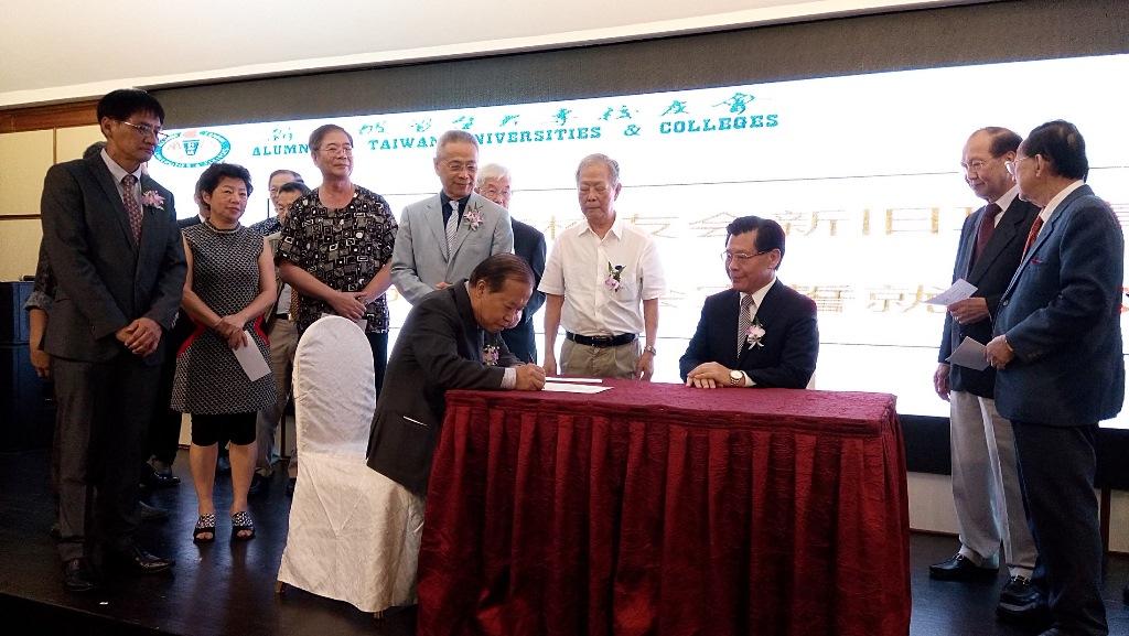 所有新任理事宣誓後現場簽字，由梁代表(坐者右)見證，圖為新任秘書長潘廣齋正完成簽字。(107年5月19日)