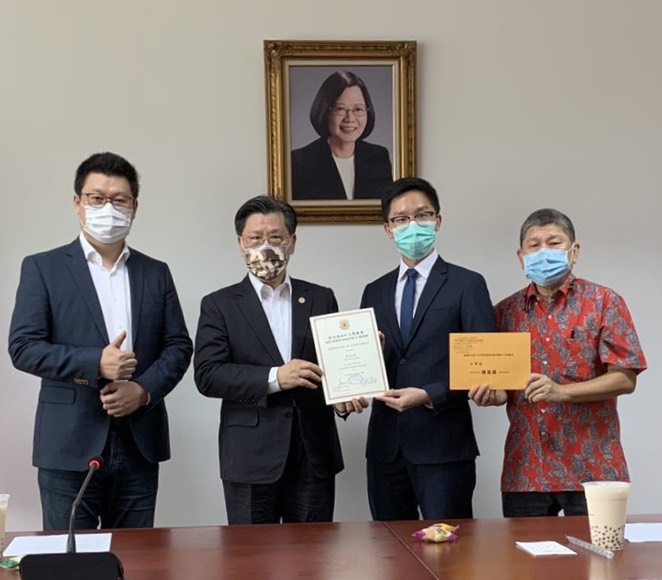 本處代表梁國新頒贈獎狀與獎勵金予大學組受獎者陳宜嘉同學(右一為家長陳尚賢先生，左一為楊會長正祺)。