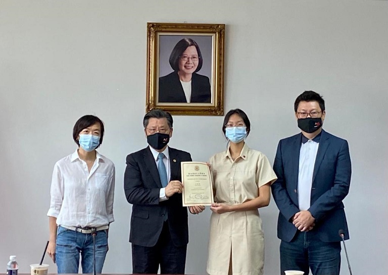 本處代表梁國新頒贈獎狀與獎勵金予中學組受獎者林毓觀同學(左一為家長徐美蓉女士，右一為楊會長正祺)。