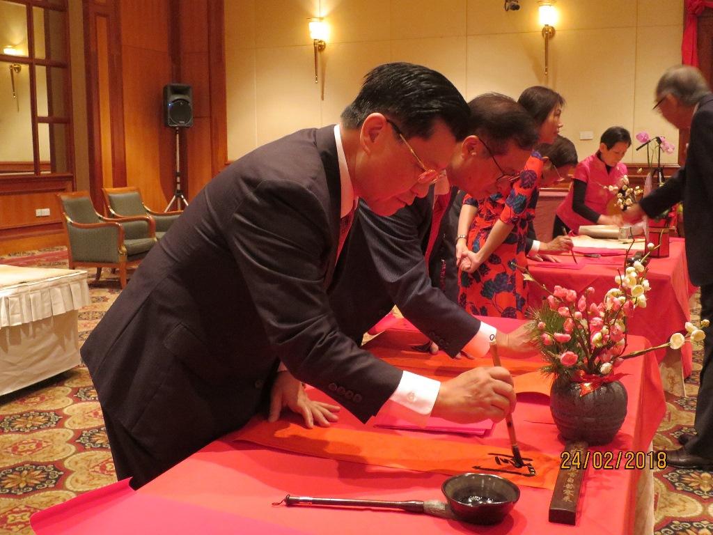 Representative Francis Liang (extreme left) joining other distinguished guests in the writing of auspicious messages on red paper to usher in the New Year.