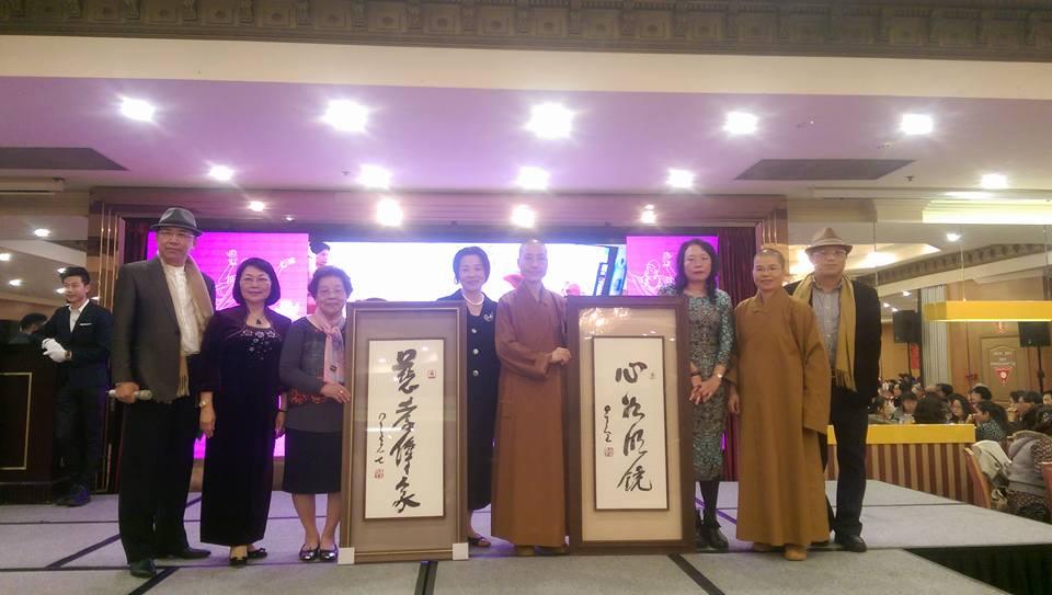 友愛服務隊年度聯誼晚會上盧淑媛僑務委員慈善捐款南天大學收藏星雲大師墨寶「慈孝傳家」並與滿望法師、覺善法師，以及黃素珍僑務委員、晚會主持人吳金明會長，楊史邦督導合影。